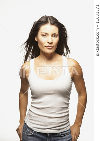 Portrait of woman in tank top with hands in pockets 11631571