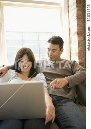 Couple using a laptop together Couple using a laptop together 11631598