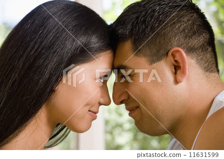 Multi-ethnic couple touching foreheads 11631599