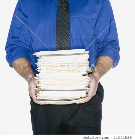 Hispanic businessman carrying stack of paperwork 11631628