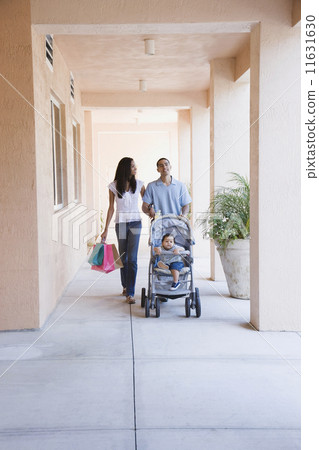 African couple pushing baby in stroller 11631630