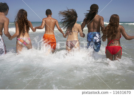 Rear view of multi-ethnic friends in ocean 11631670
