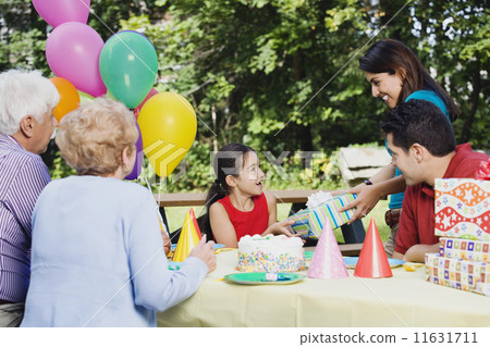 Hispanic girl receiving gifts at birthday party Hispanic girl receiving gifts at birthday party 11631711