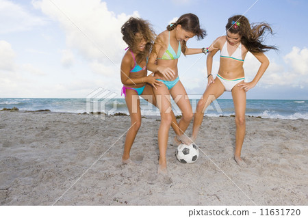 Multi-ethnic girls playing soccer at beach Multi-ethnic girls playing soccer at beach 11631720