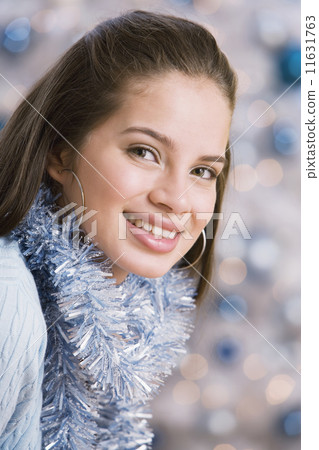 Hispanic teenaged girl wearing Christmas garland Hispanic teenaged girl wearing Christmas garland 11631763
