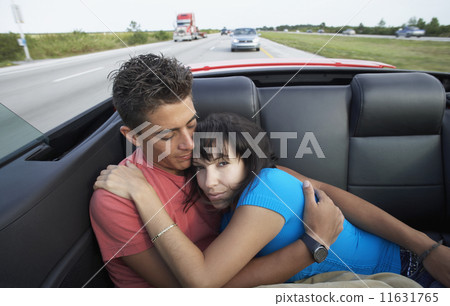 Multi-ethnic couple in back of convertible 11631765