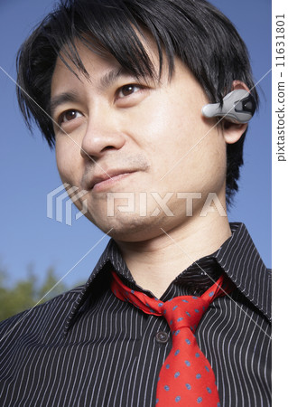 Asian man using hands free device Asian man using hands free device 11631801