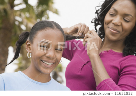 African mother braiding daughter's hair African mother braiding daughter's hair 11631832