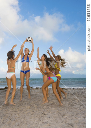 Multi-ethnic girls playing with soccer ball at beach Multi-ethnic girls playing with soccer ball at beach 11631888