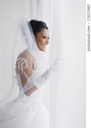 Hispanic bride looking out window Hispanic bride looking out window 11631965