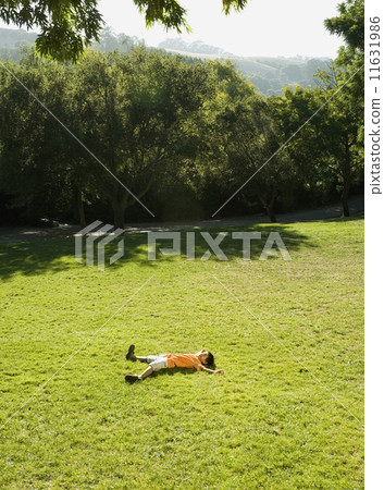 Asian boy laying in grass 11631986
