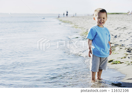 Boy standing on beach Boy standing on beach 11632106