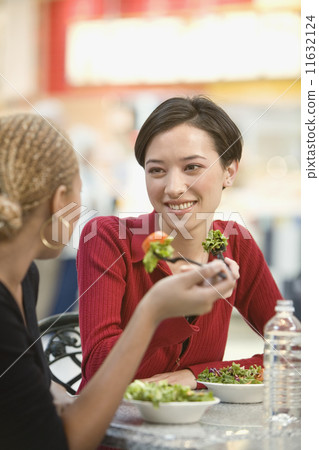 Mixed Race women eating salad Mixed Race women eating salad 11632124