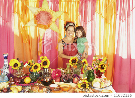 Mixed Race mother and daughter behind buffet table Mixed Race mother and daughter behind buffet table 11632136