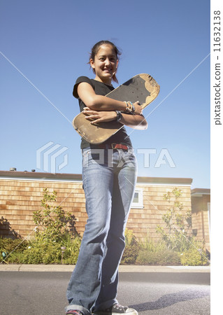 Teenage girl holding skateboard Teenage girl holding skateboard 11632138