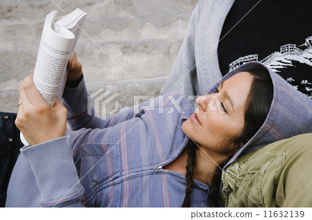 Hispanic woman reading outdoors Hispanic woman reading outdoors 11632139