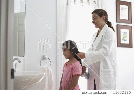Mother brushing daughter's hair Mother brushing daughter's hair 11632150