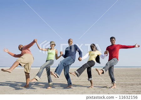 Multi-ethnic friends holding hands and kicking Multi-ethnic friends holding hands and kicking 11632156