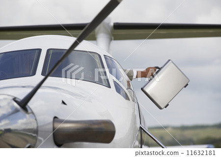 Businessman holding briefcase out of airplane 11632181