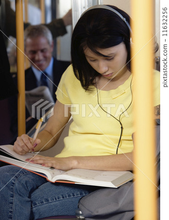 Teenager doing homework on subway 11632256
