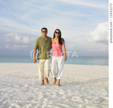 Couple walking on the beach 11632273
