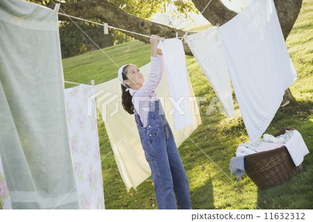 Pacific Islander girl hanging laundry on clothesline Pacific Islander girl hanging laundry on clothesline 11632312