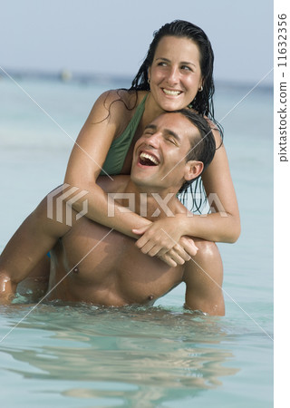 Hispanic couple playing in water 11632356