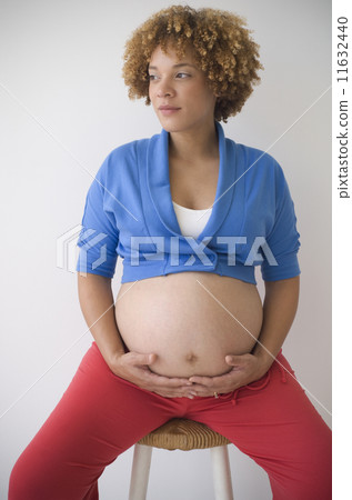 Pregnant African woman with hands on belly 11632440