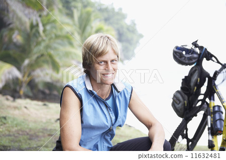 Female cyclist next to bicycle Female cyclist next to bicycle 11632481
