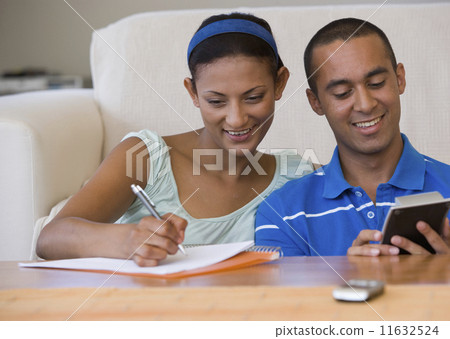 Young couple using calculator 11632524