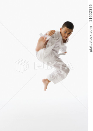 Studio shot of Hispanic boy performing martial arts kick 11632556