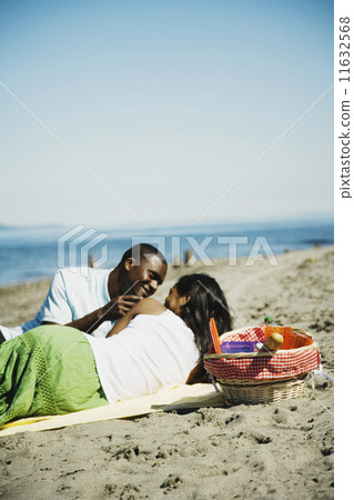 African couple having picnic on beach African couple having picnic on beach 11632568