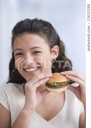 Hispanic girl eating hamburger 11632589
