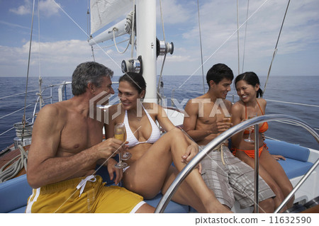 Multi-ethnic couples drinking champagne on sailboat 11632590