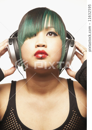 Asian woman listening to headphones Asian woman listening to headphones 11632595