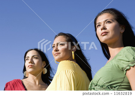 Row of multi-ethnic women under blue sky 11632819