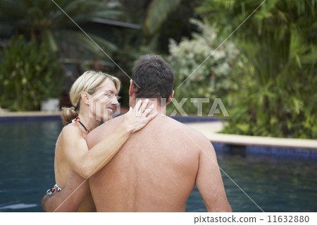 Couple hugging next to swimming pool Couple hugging next to swimming pool 11632880