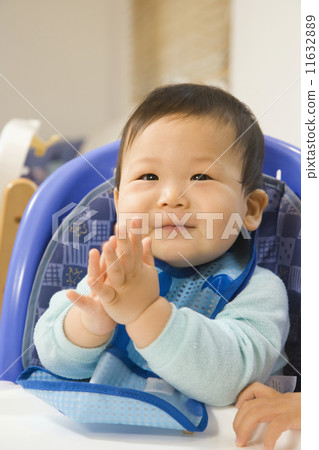 Asian baby clapping in highchair 11632889