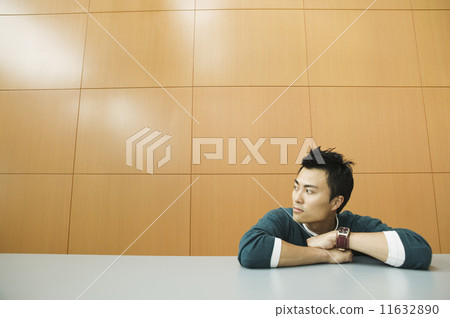 Businessman sitting at a table looking at the side 11632890