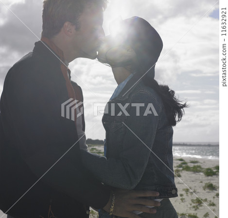 Couple kissing on the beach  11632921
