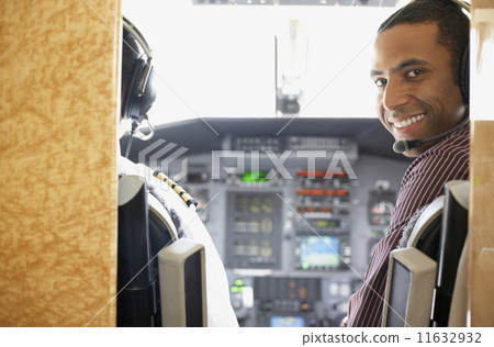 Mixed Race male pilot in airplane cockpit Mixed Race male pilot in airplane cockpit 11632932