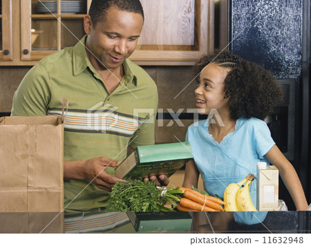 African father and daughter with groceries in kitchen African father and daughter with groceries in kitchen 11632948