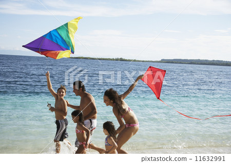 Hispanic family flying kites at beach Hispanic family flying kites at beach 11632991
