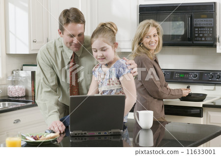 Family making breakfast and looking at laptop 11633001