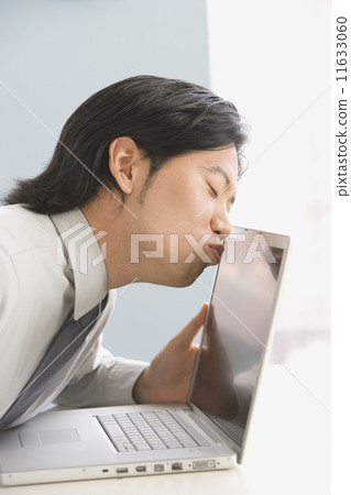 Asian businessman kissing laptop Asian businessman kissing laptop 11633060