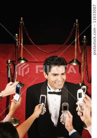 Fans taking pictures of a male celebrity with camera phones 11633087