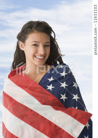 Hispanic teenaged girl wrapped in American flag 11633103