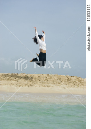 Woman jumping at beach 11633111