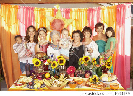 Multi-ethnic Mixed Race female family members behind buffet table Multi-ethnic Mixed Race female family members behind buffet table 11633129