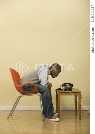 African man staring at telephone African man staring at telephone 11633134